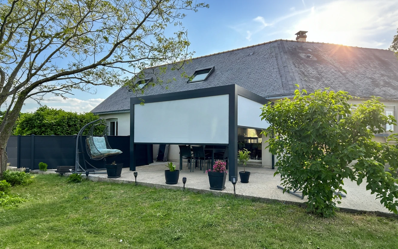 Terrasse couverte par une pergola bioclimatique aluminium anthracite, équipée d'une toile screen extérieure déployée en façade